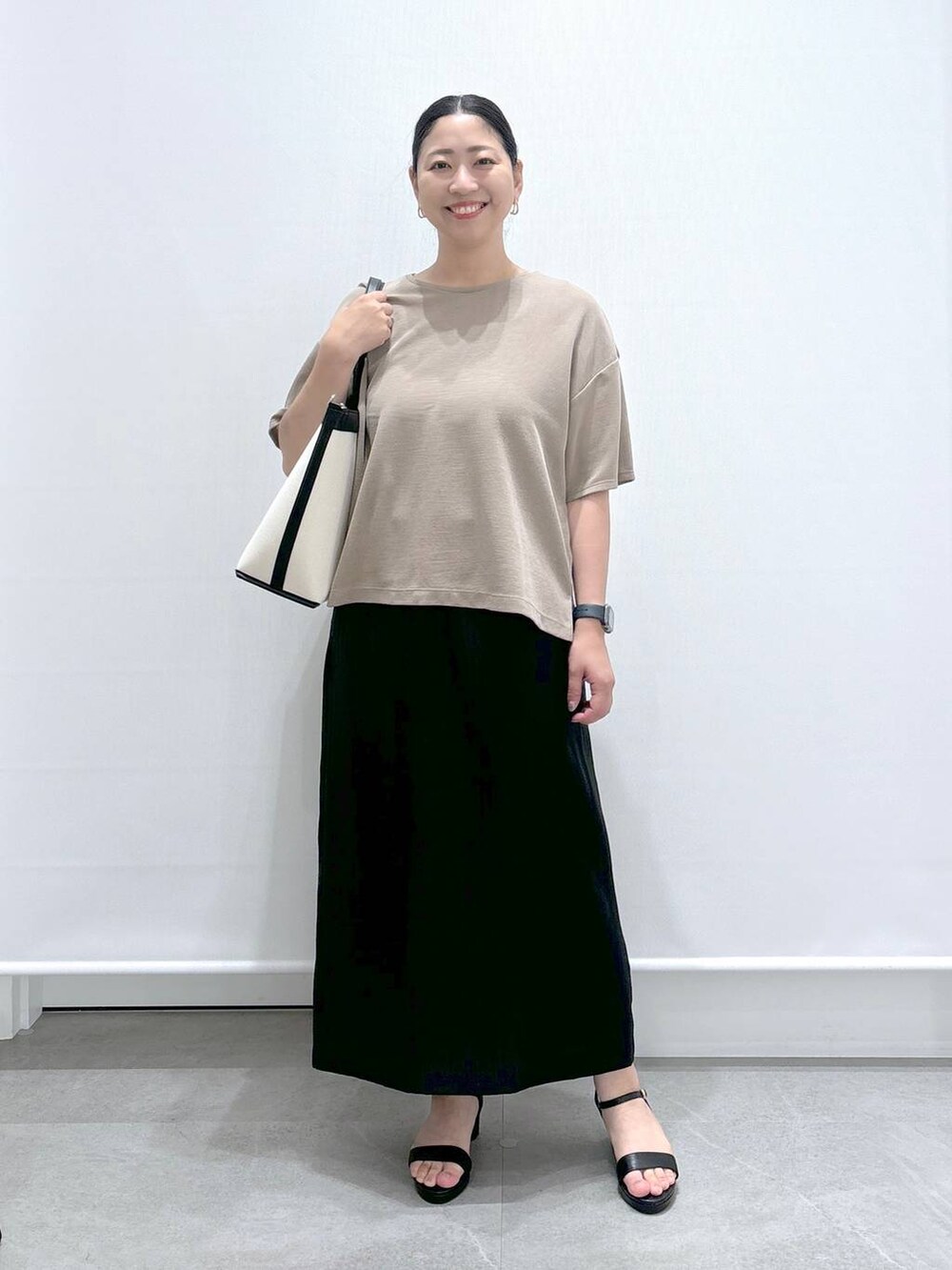 ブラック系のトートバッグ、ブラック系のサンダル、ブラック系のスカートを着用したレディースの夏コーディネートの2枚目の写真