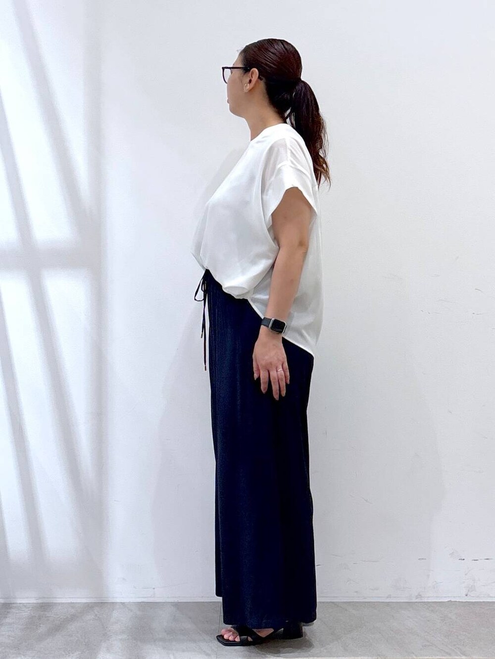 ブルー系のその他パンツ、ブラック系のサンダル、ホワイト系のTシャツ/カットソーを着用したレディースの夏コーディネートの3枚目の写真