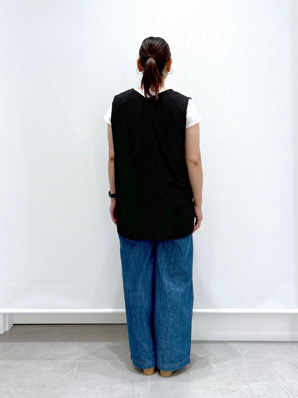 ブルー系のデニムパンツ、ブラック系のシャツ/ブラウス、ホワイト系のサンダルを着用したレディースの夏コーディネートの4枚目の写真