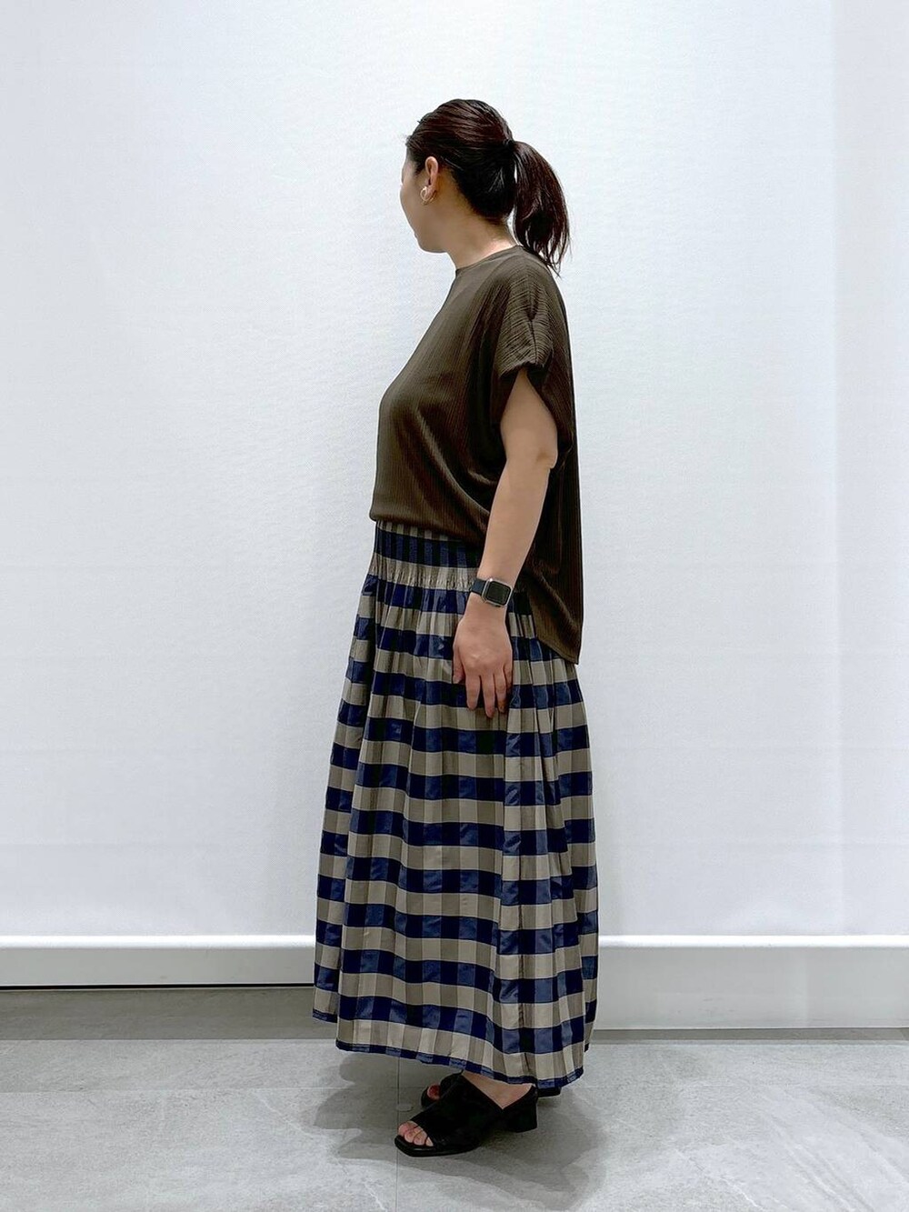 ブラック系のサンダル、グリーン系のTシャツ/カットソー、グリーン系のスカートを着用したレディースの夏コーディネートの4枚目の写真