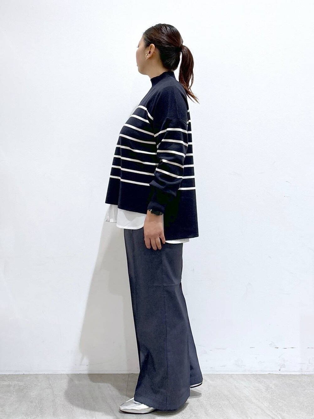 シルバー系のローファー、ブルー系のニット/セーター、ブルー系のデニムパンツを着用したレディースの秋コーディネートの3枚目の写真