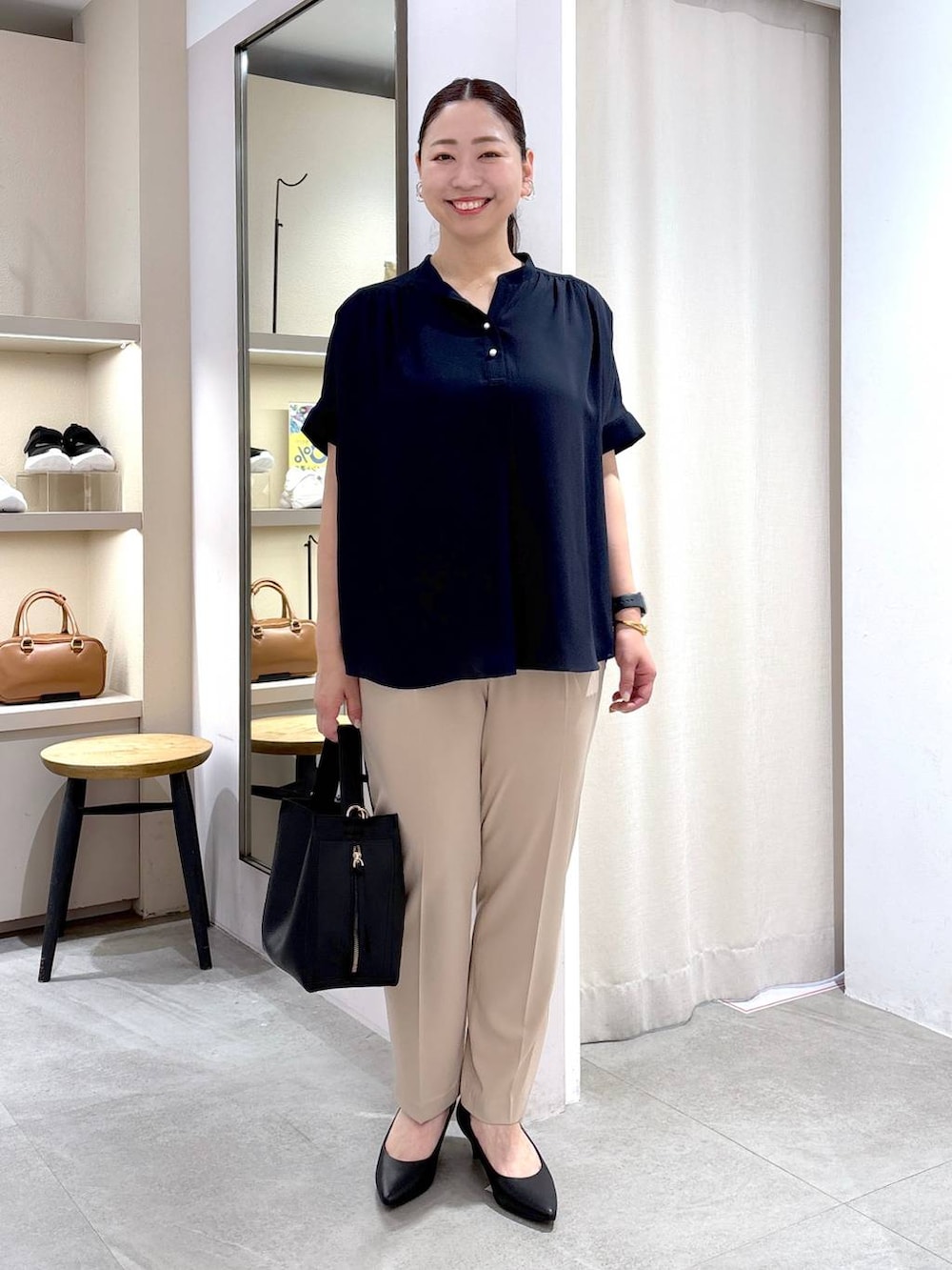 ブラック系のパンプス、ブラック系のハンドバッグ、ベージュ系のその他パンツを着用したレディースの春コーディネートの2枚目の写真