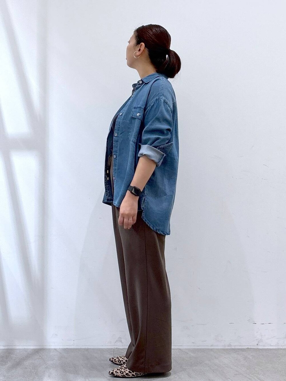 ブラック系のショルダーバッグ、ブルー系のシャツ/ブラウス、ブラウン系のその他パンツを着用したレディースの秋コーディネートの3枚目の写真