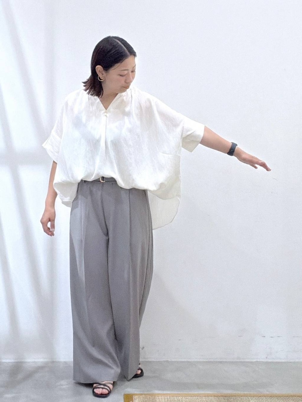 グレー系のその他パンツ、ホワイト系のシャツ/ブラウス、ブラック系のサンダルを着用したレディースの夏コーディネートの6枚目の写真
