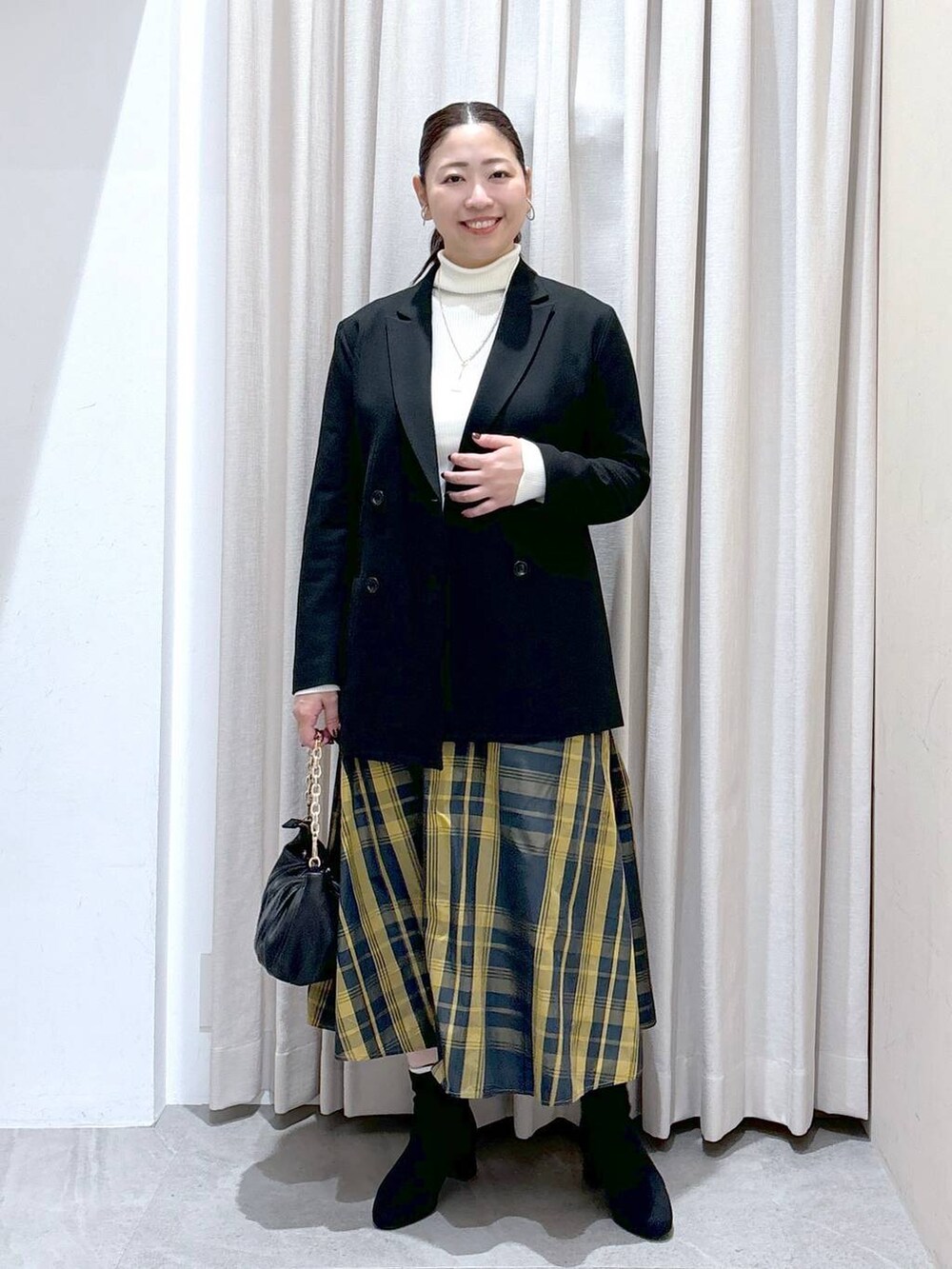 グレー系のブーツ、ブラック系のその他アウターを着用したレディースの秋コーディネートの2枚目の写真