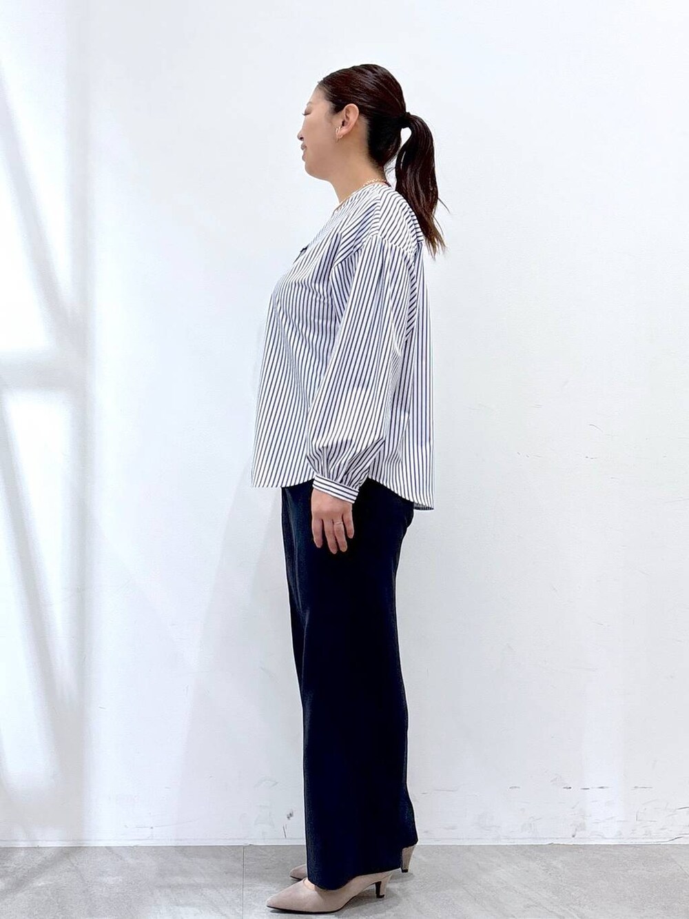 ブルー系のその他パンツ、ベージュ系のパンプス、ホワイト系のハンドバッグを着用したレディースの春コーディネートの3枚目の写真