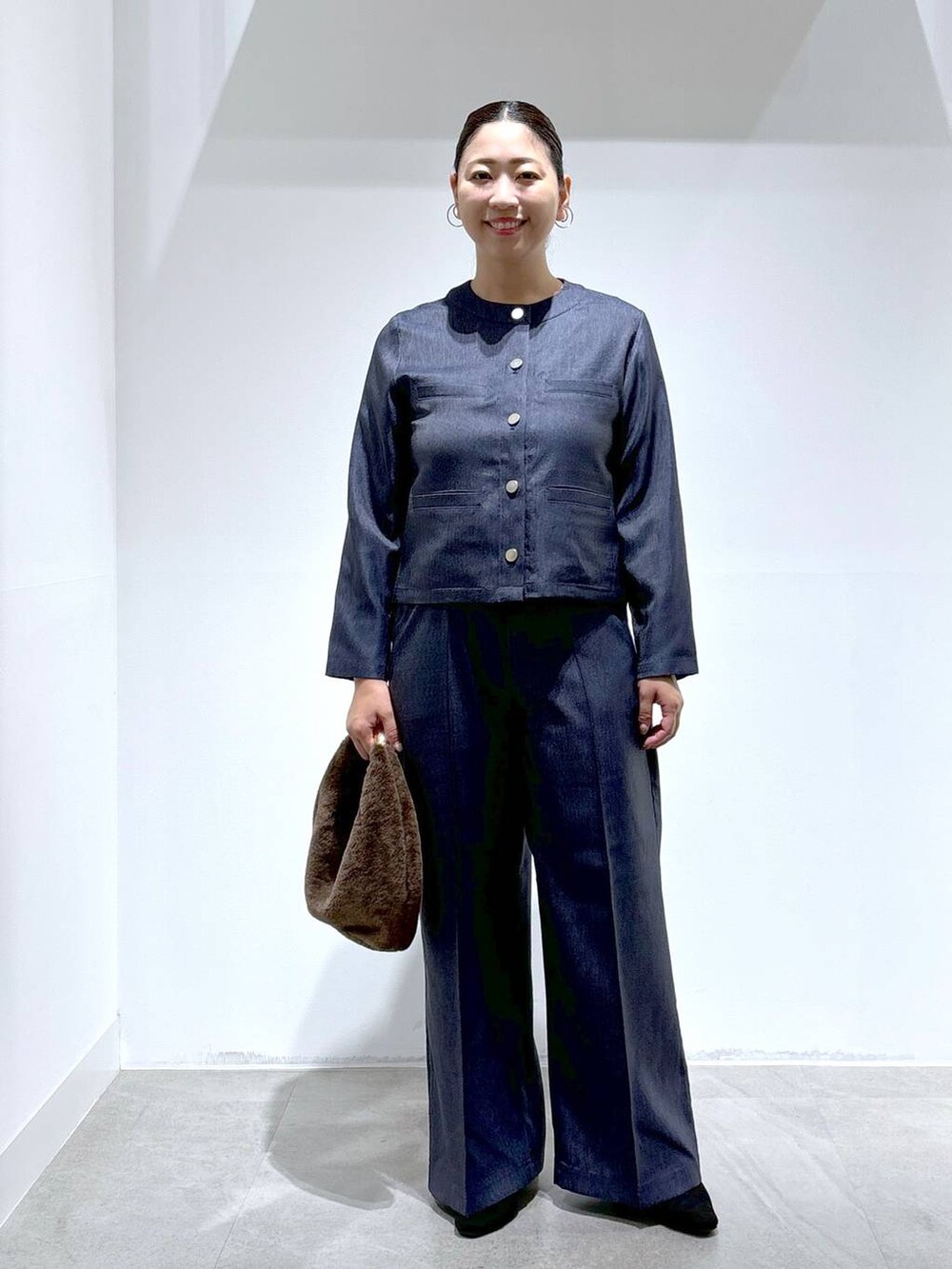 ブルー系のデニムパンツ、ブルー系のデニムパンツ、ブラック系のパンプスを着用したレディースの秋コーディネートの2枚目の写真