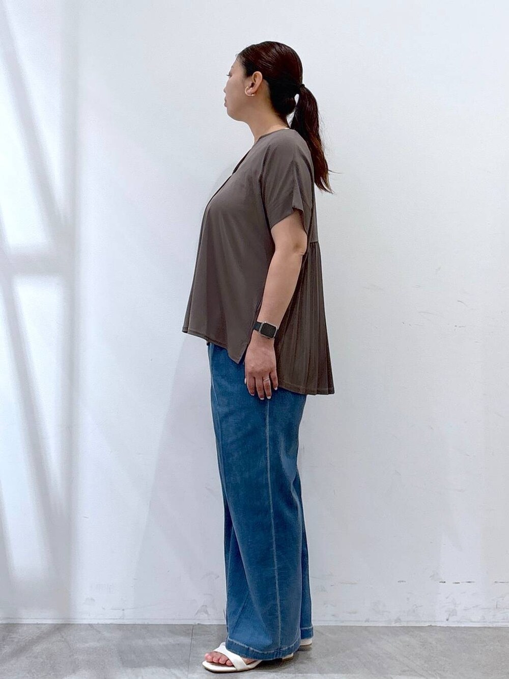 グリーン系のTシャツ/カットソー、シルバー系のトートバッグ、ブルー系のデニムパンツを着用したレディースの夏コーディネートの3枚目の写真