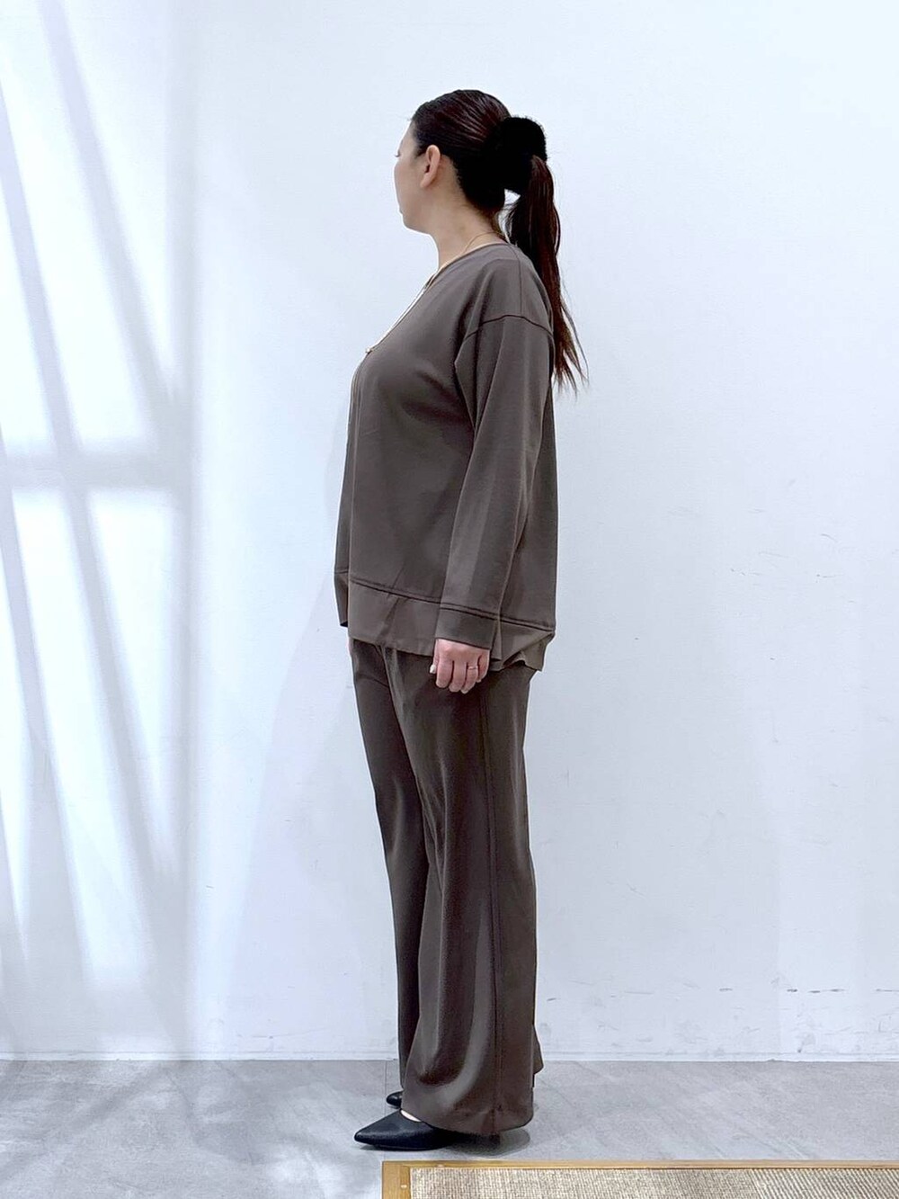 ブラウン系のその他パンツ、ブラウン系のTシャツ/カットソー、ブラック系のハンドバッグを着用したレディースの冬コーディネートの3枚目の写真