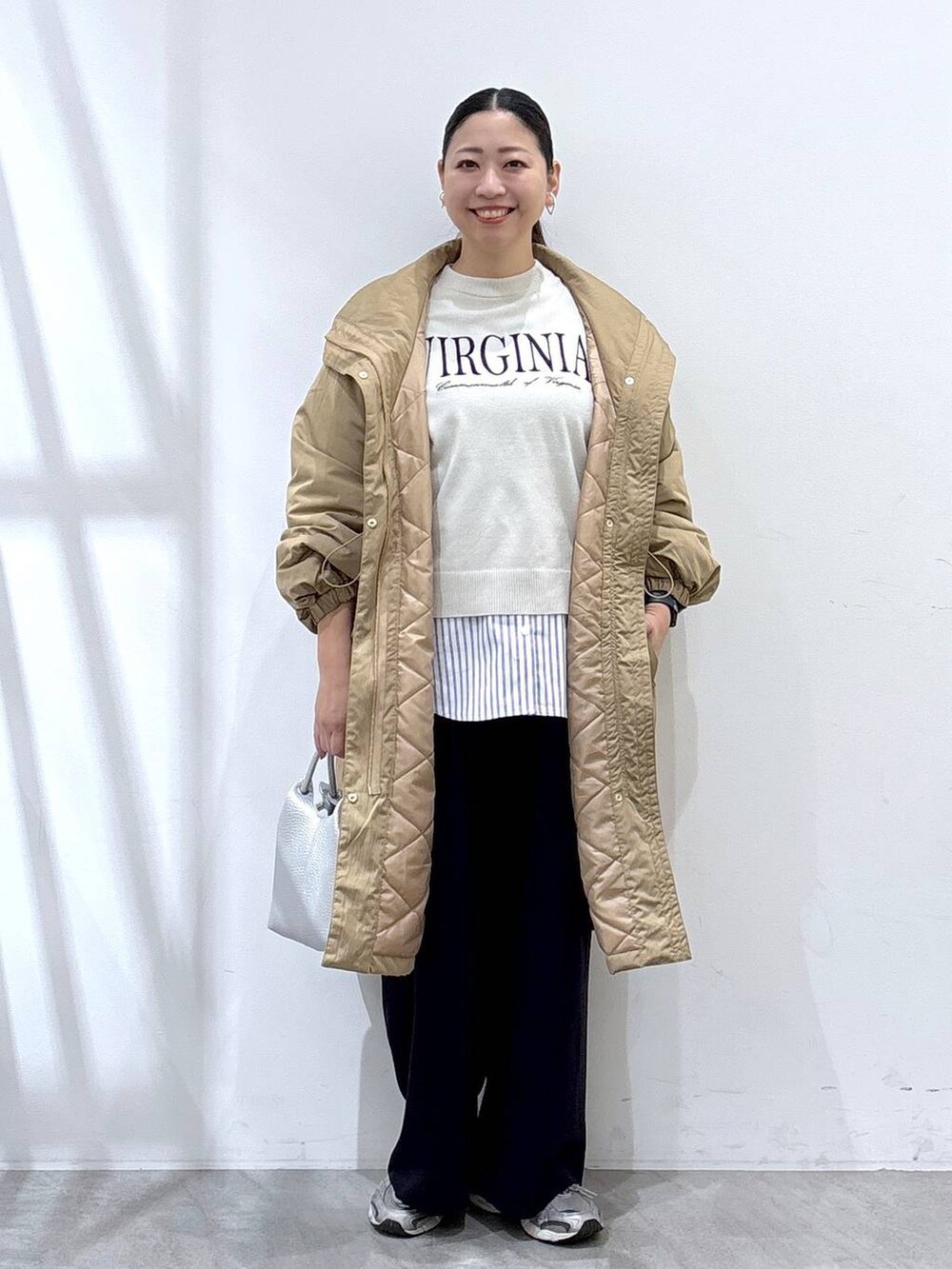 グレー系のスニーカー、イエロー系のダウンジャケット/コート、ベージュ系のTシャツ/カットソーを着用したレディースの秋コーディネートの2枚目の写真