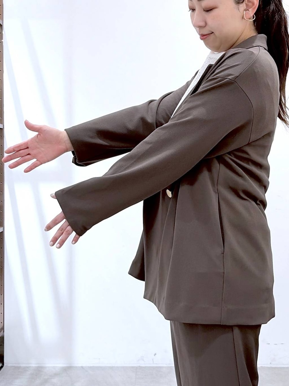 ブラウン系のその他パンツ、ブラック系のハンドバッグ、ブラウン系のテーラードジャケットを着用したレディースの春コーディネートの6枚目の写真