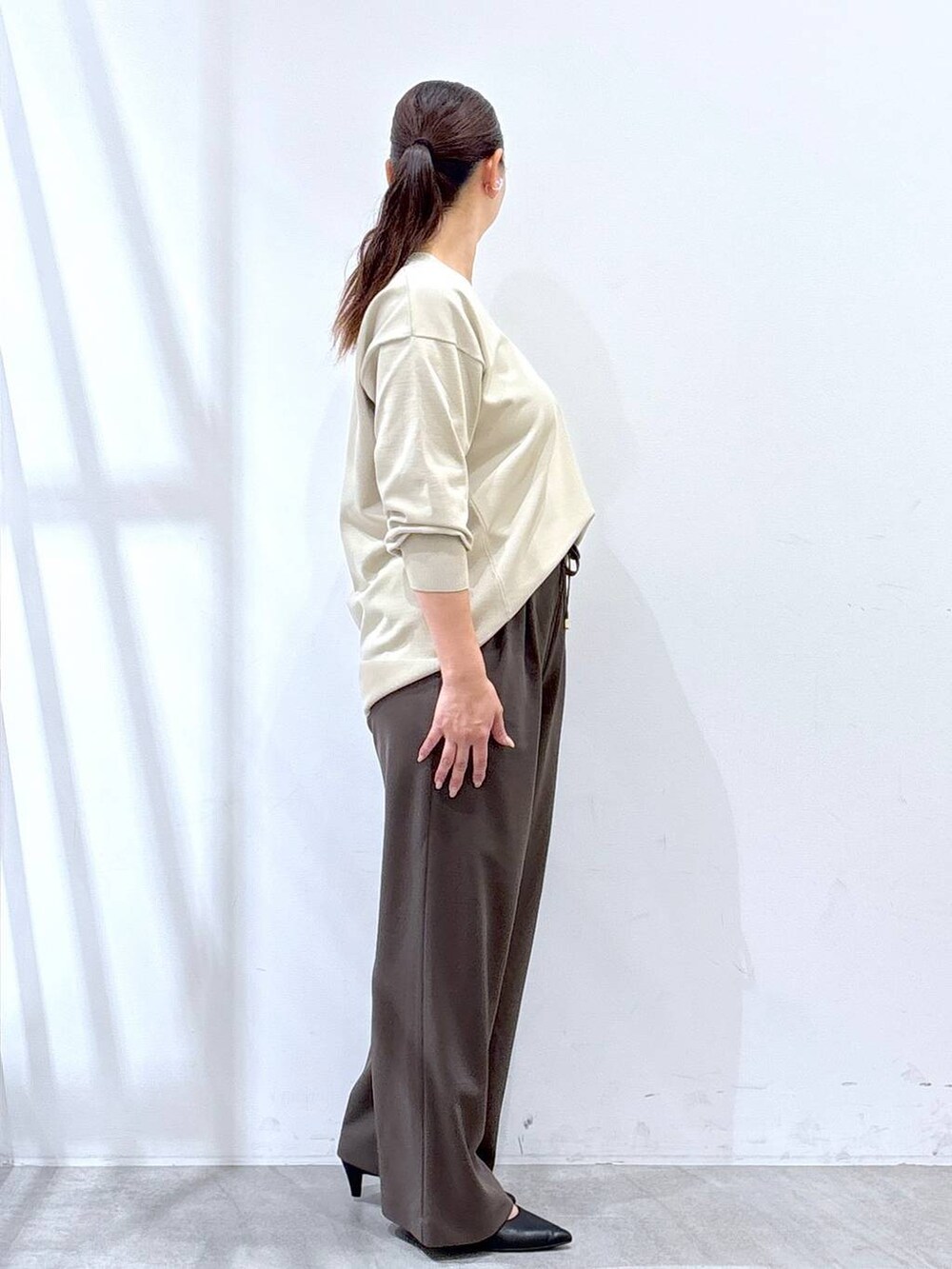 ブラック系のパンプス、ブラック系のハンドバッグ、ブラウン系のその他パンツを着用したレディースの秋コーディネートの5枚目の写真