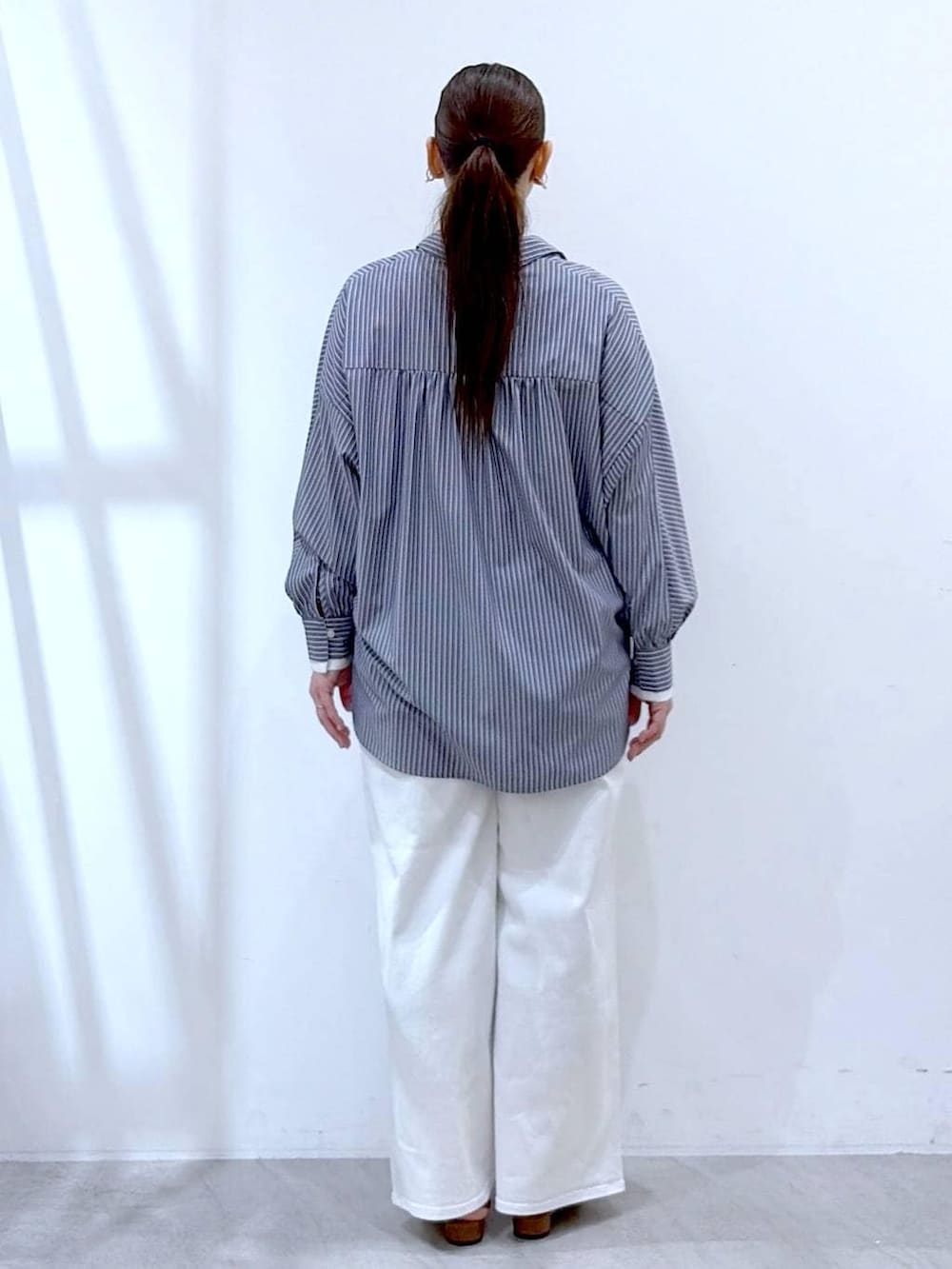 ホワイト系のデニムパンツ、イエロー系のハンドバッグ、ブルー系のシャツ/ブラウスを着用したレディースの春コーディネートの4枚目の写真