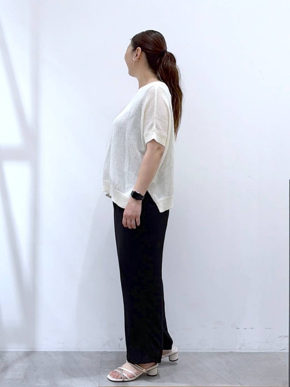 ホワイト系のニット/セーター、ブラック系のその他パンツ、ホワイト系のハンドバッグを着用したレディースの夏コーディネートの3枚目の写真