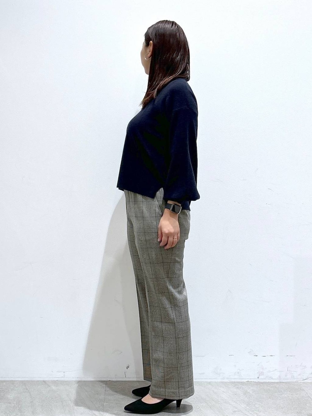 ブラック系のトートバッグ、ブルー系のニット/セーター、ブラック系のパンプスを着用したレディースの冬コーディネートの3枚目の写真