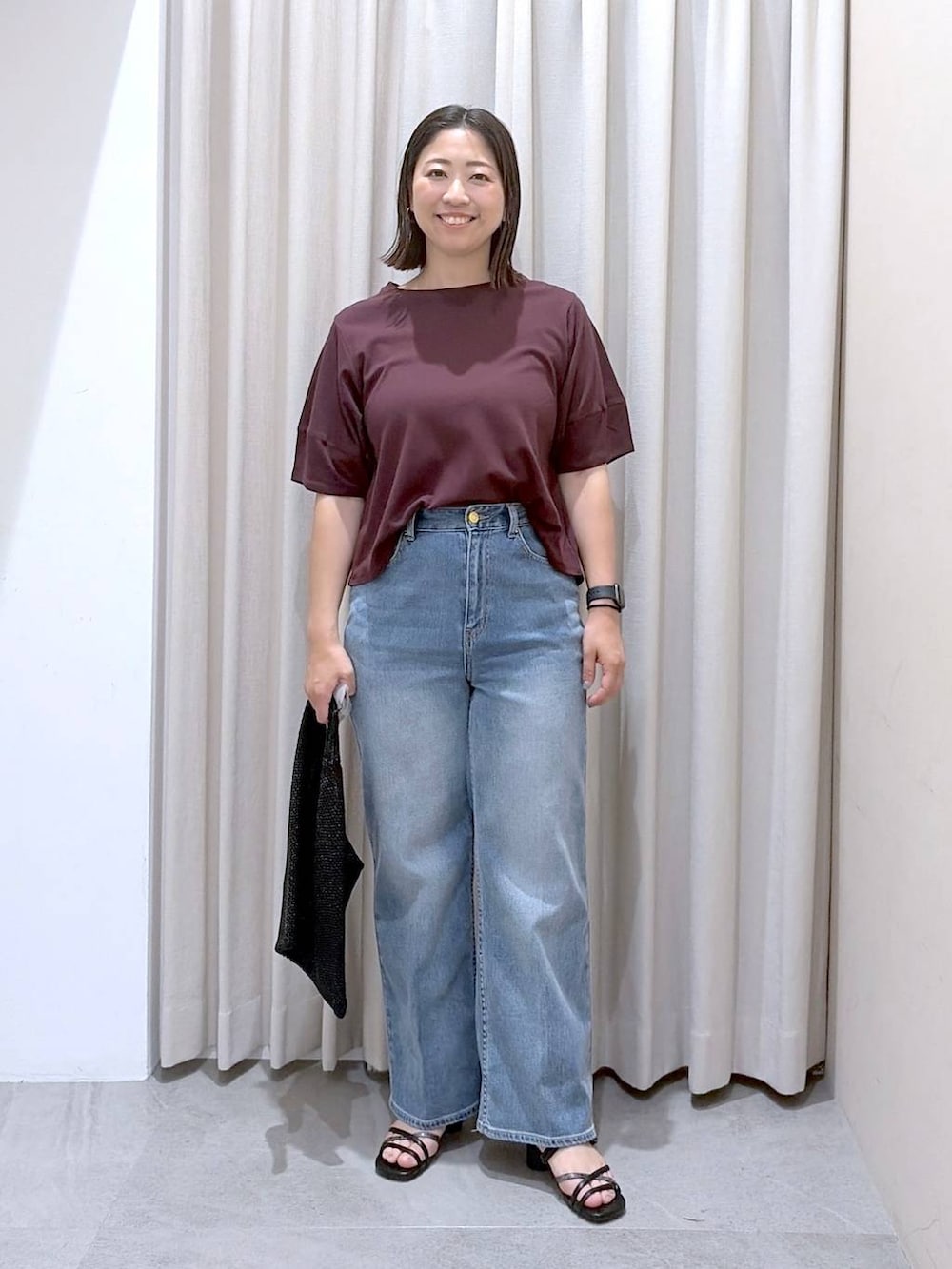レッド系のTシャツ/カットソー、ブラック系のサンダル、ブルー系のデニムパンツを着用したレディースの夏コーディネートの2枚目の写真