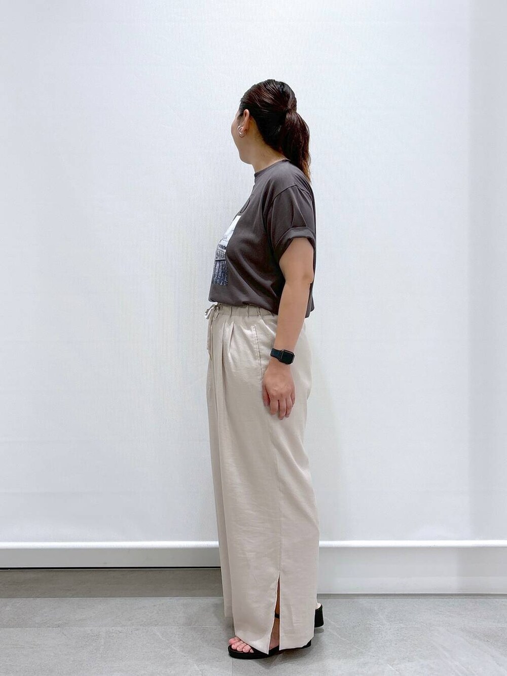 ベージュ系のその他パンツ、ブラック系のサンダル、グレー系のTシャツ/カットソーを着用したレディースの夏コーディネートの3枚目の写真