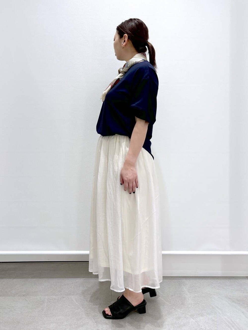 ホワイト系のスカート、ブラック系のショルダーバッグ、ブラック系のサンダルを着用したレディースの春コーディネートの3枚目の写真