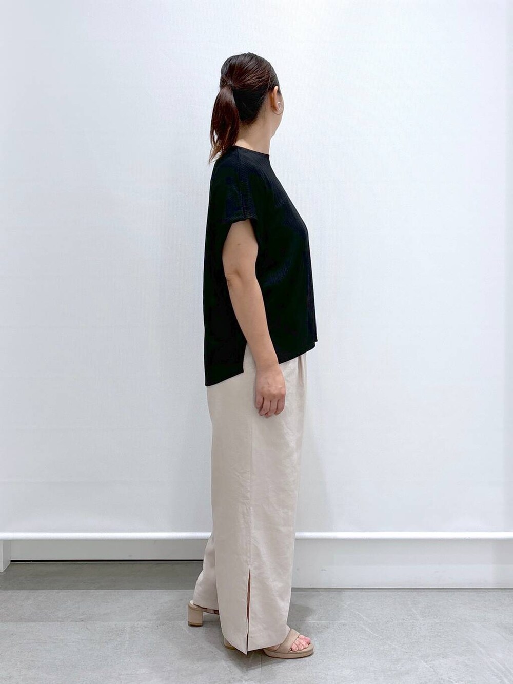 ベージュ系のその他パンツ、ブラック系のTシャツ/カットソー、ベージュ系のサンダルを着用したレディースの夏コーディネートの5枚目の写真