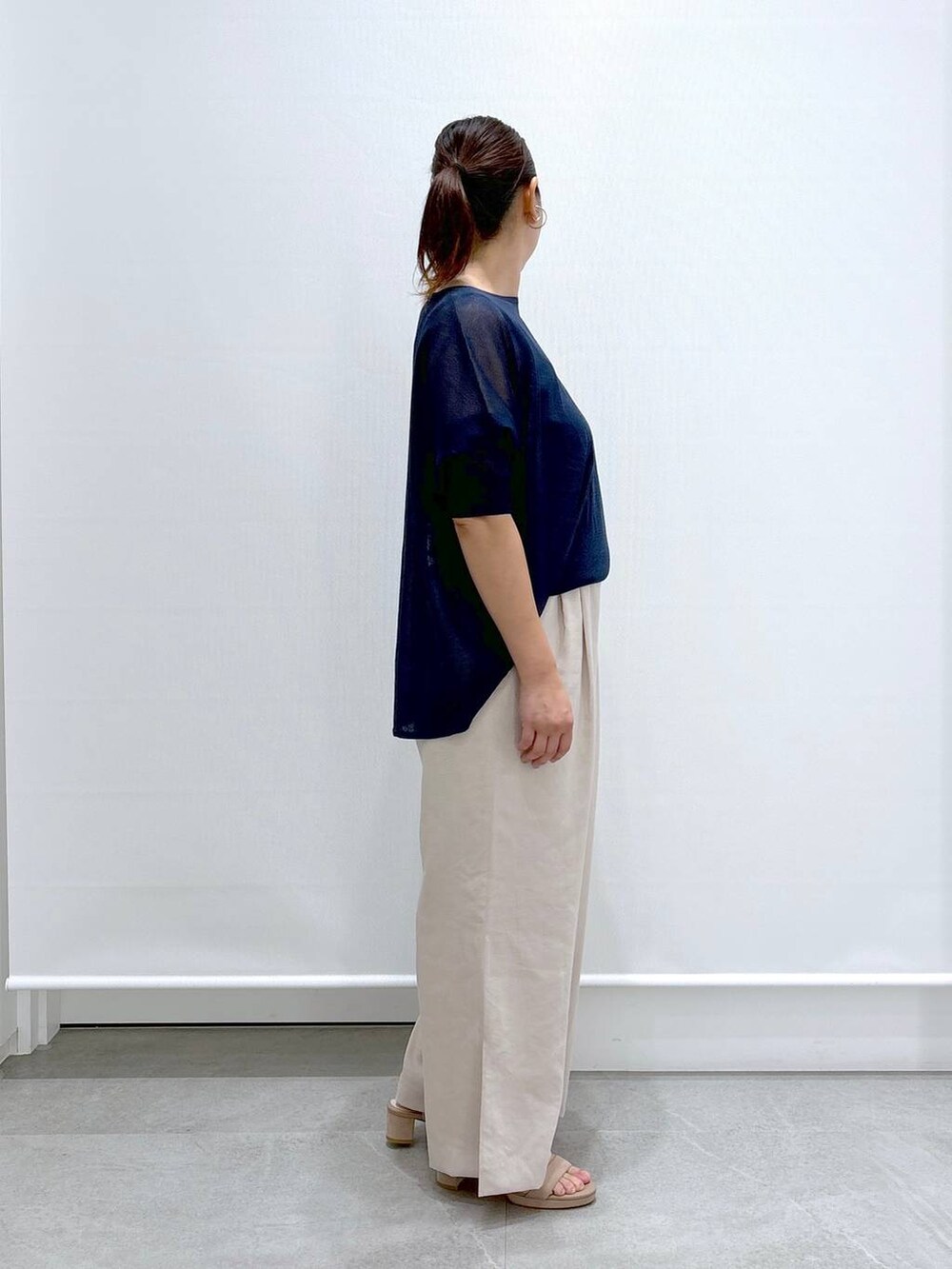 ベージュ系のその他パンツ、ベージュ系のサンダル、ブルー系のニット/セーターを着用したレディースの夏コーディネートの5枚目の写真