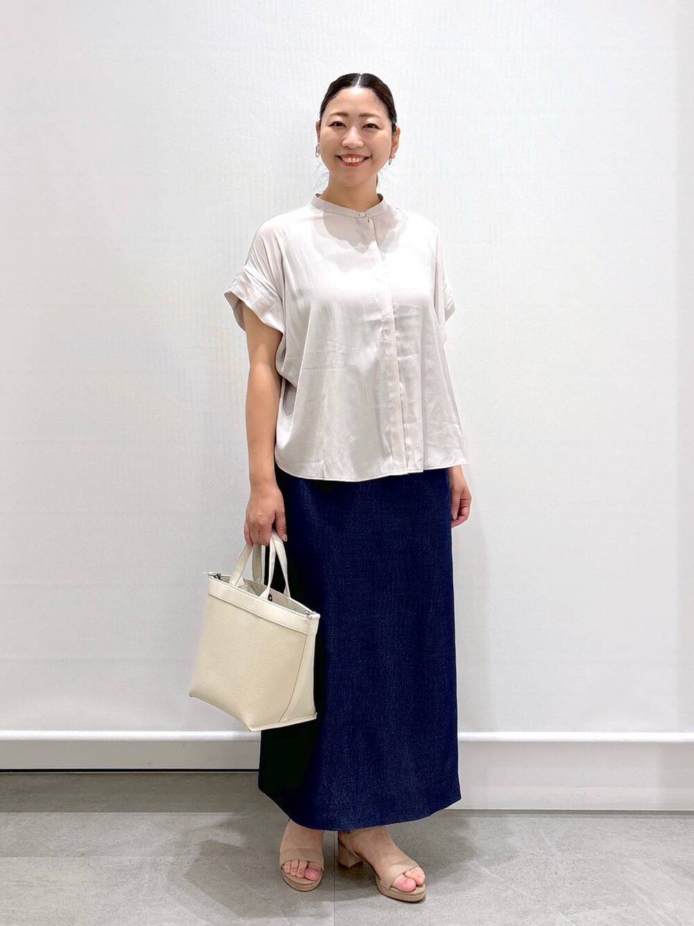 ベージュ系のシャツ/ブラウス、ベージュ系のサンダル、ブルー系のデニムスカートを着用したレディースの夏コーディネートの2枚目の写真