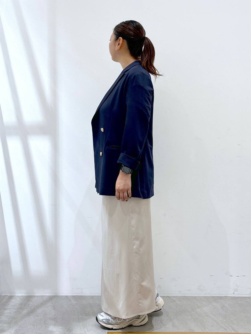 グレー系のスニーカー、シルバー系のトートバッグ、ホワイト系のTシャツ/カットソーを着用したレディースの秋コーディネートの3枚目の写真