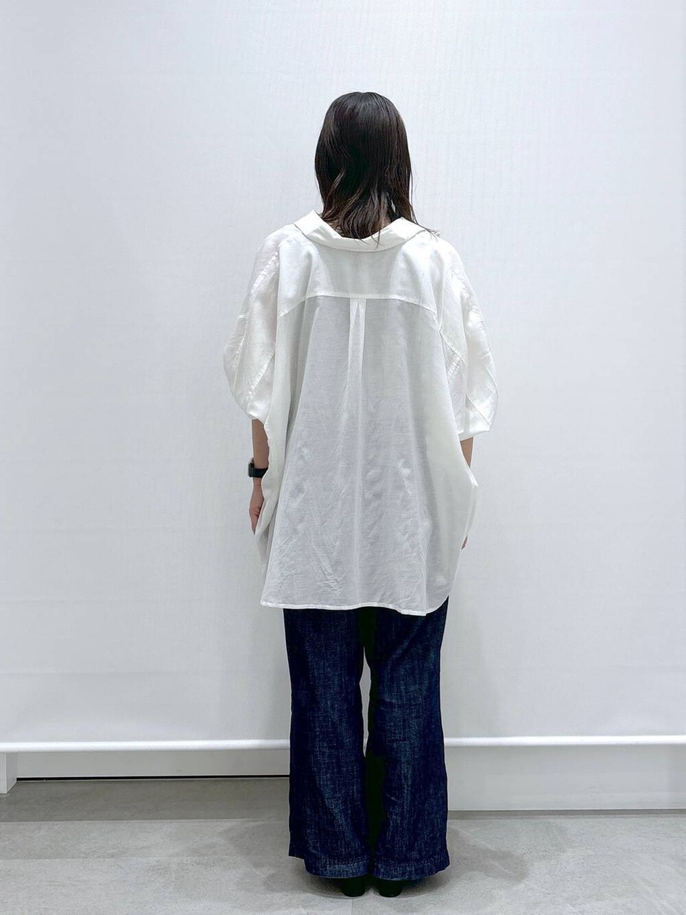 ブルー系のデニムパンツ、ホワイト系のTシャツ/カットソー、ブラック系のサンダルを着用したレディースの夏コーディネートの4枚目の写真