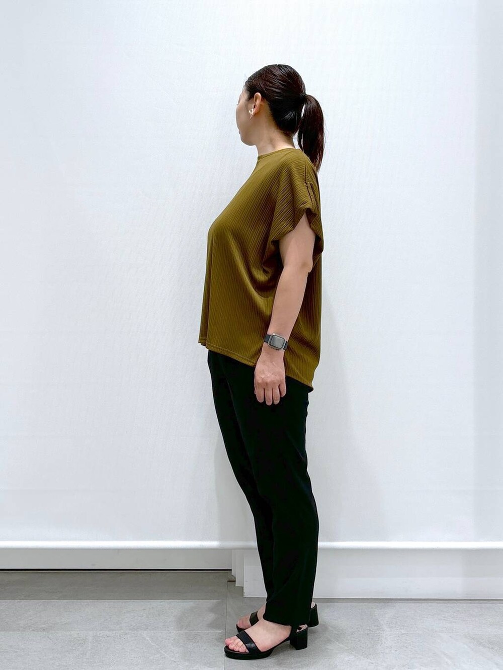 ブラック系のその他パンツ、グリーン系のTシャツ/カットソー、ブラック系のサンダルを着用したレディースの夏コーディネートの3枚目の写真