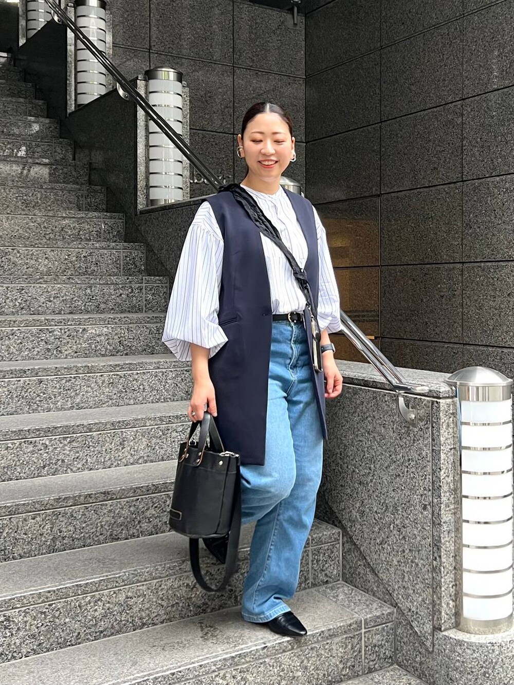 ブルー系のスーツベスト、ブルー系のデニムパンツを着用したレディースの春コーディネートの3枚目の写真