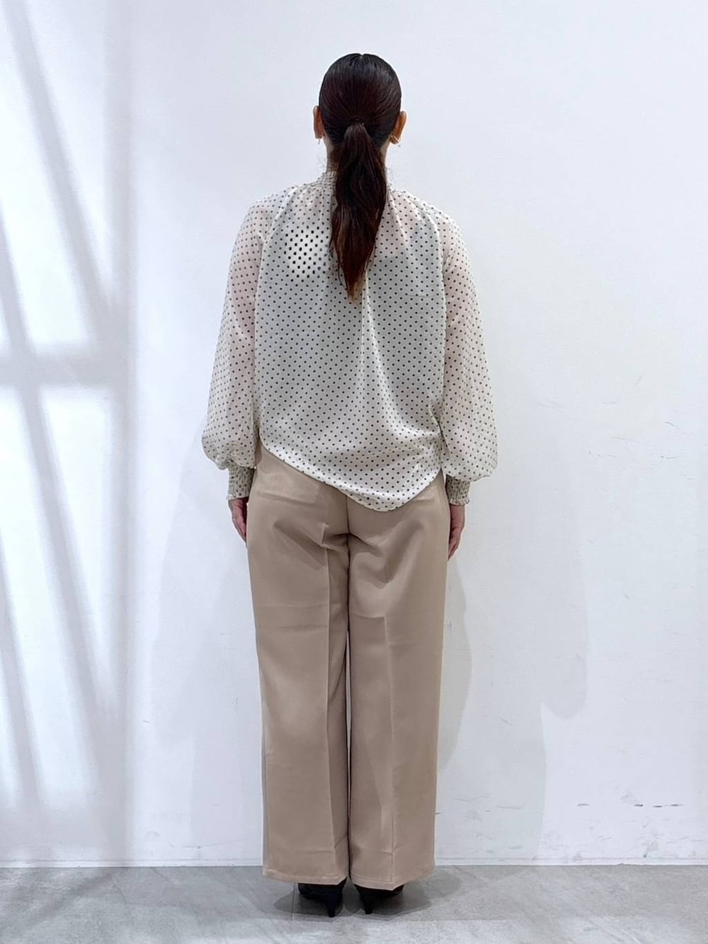 ブラック系のパンプス、ブラック系のカーディガン/ボレロ、ブラック系のハンドバッグを着用したレディースの秋コーディネートの5枚目の写真