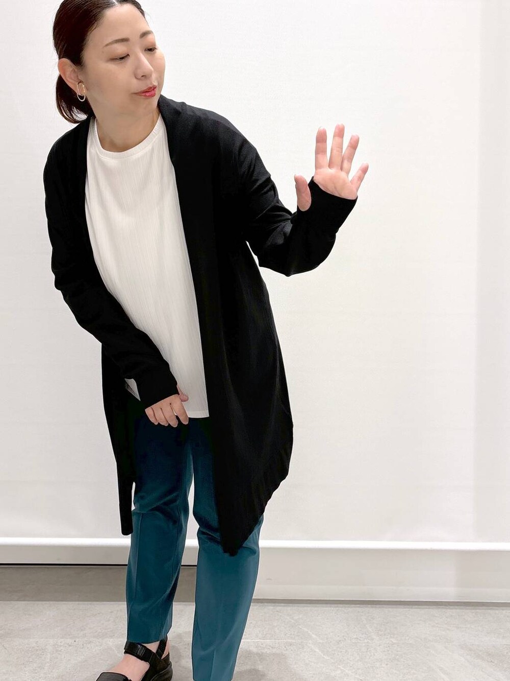 グリーン系のその他パンツ、ブラック系のハンドバッグ、ブラック系のサンダルを着用したレディースの春コーディネートの6枚目の写真