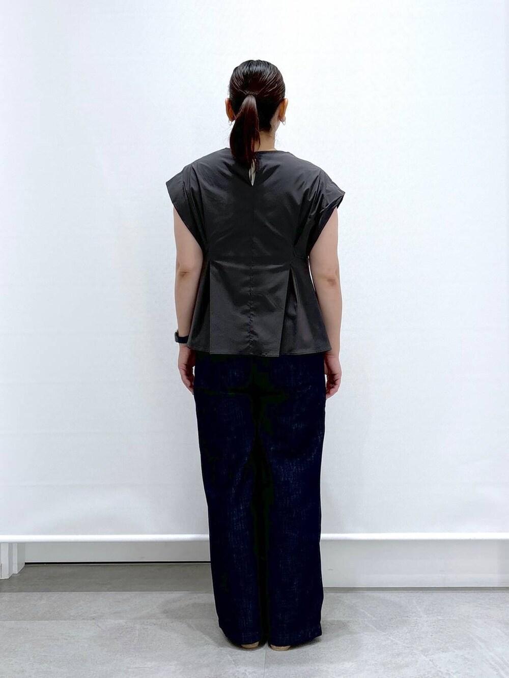 ブルー系のデニムパンツ、ベージュ系のサンダル、グレー系のシャツ/ブラウスを着用したレディースの夏コーディネートの4枚目の写真