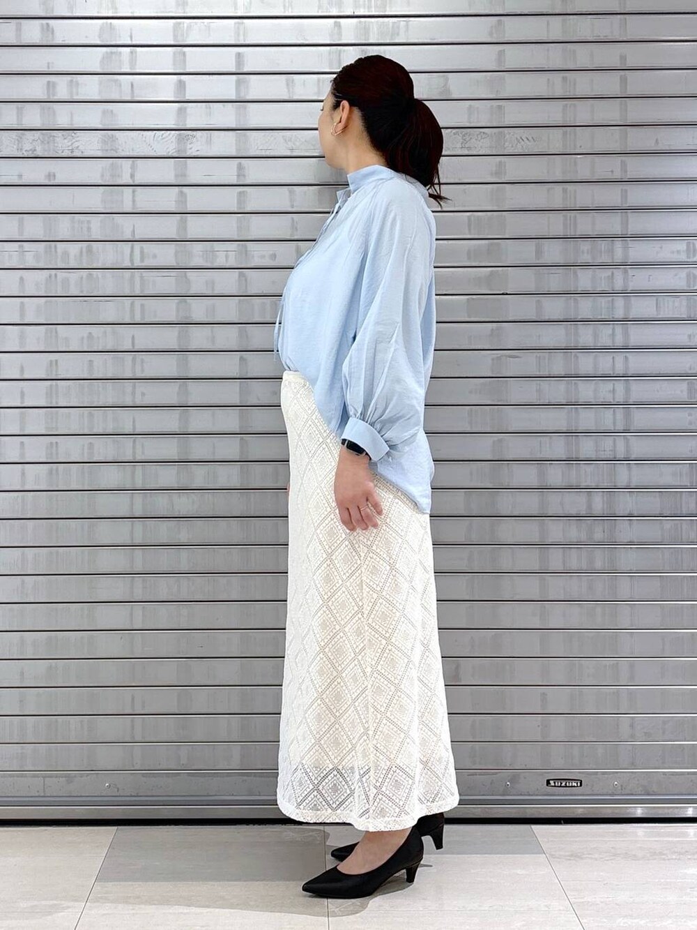 ブラック系のパンプス、ブラック系のハンドバッグ、ブルー系のシャツ/ブラウスを着用したレディースの春コーディネートの3枚目の写真