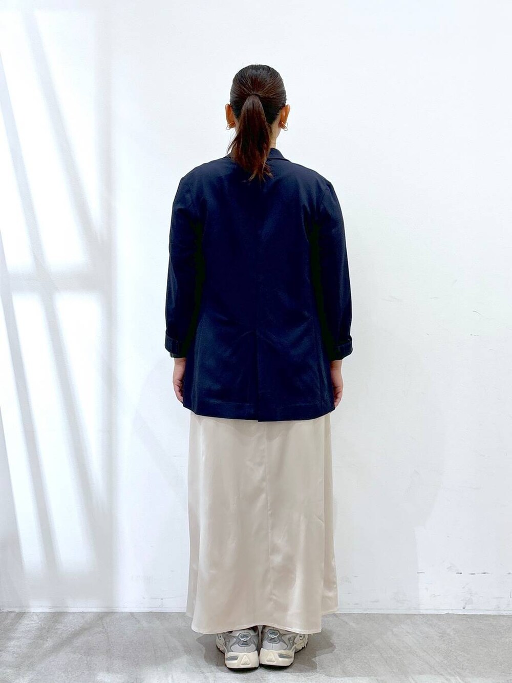 グレー系のスニーカー、シルバー系のトートバッグ、ホワイト系のTシャツ/カットソーを着用したレディースの秋コーディネートの4枚目の写真