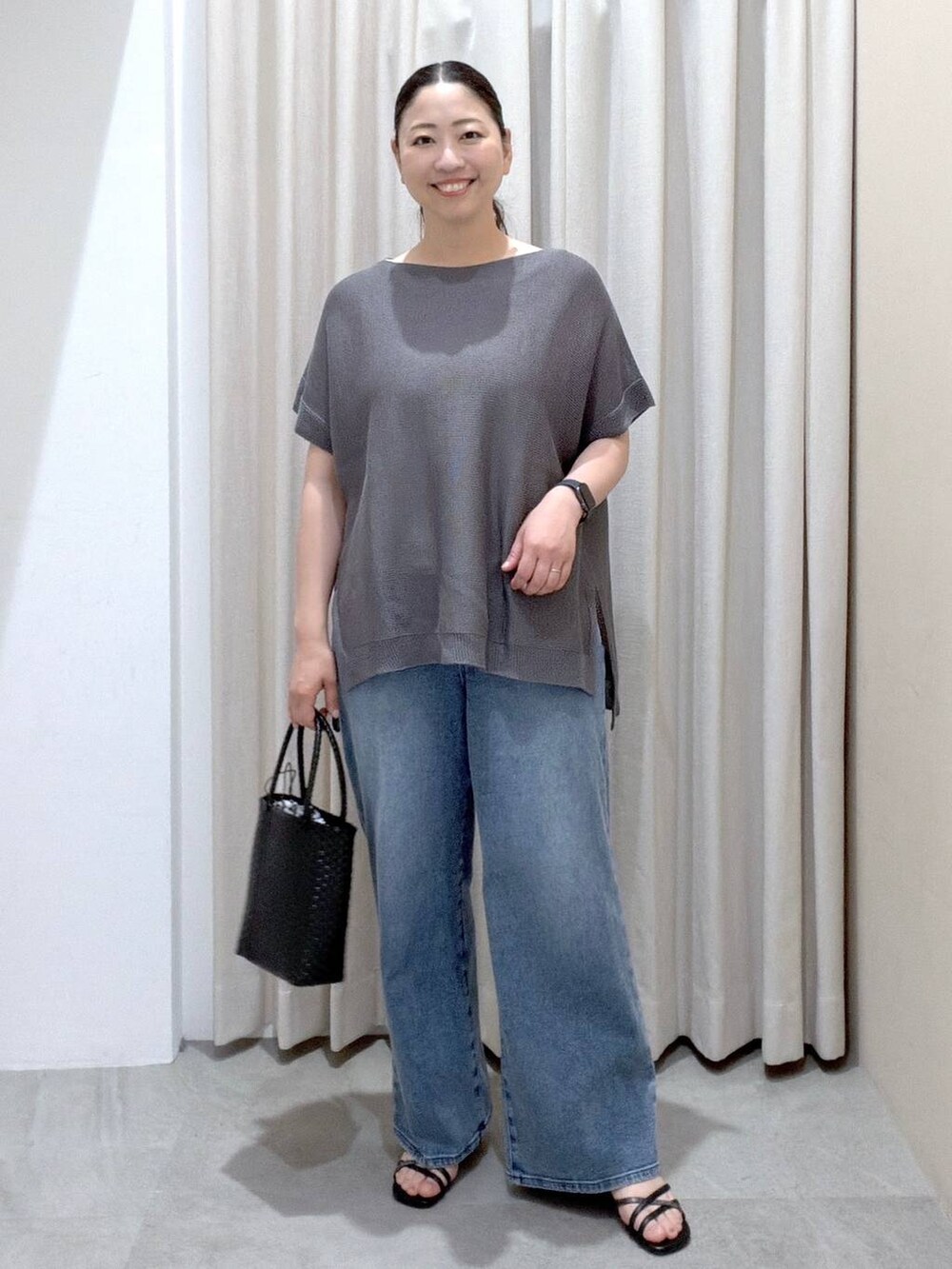 ブラック系のサンダル、ブラック系のかごバッグ、ブルー系のデニムパンツを着用したレディースの夏コーディネートの2枚目の写真
