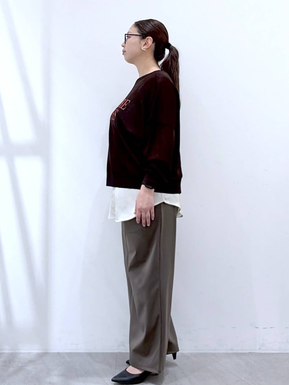 ブラック系のハンドバッグ、グリーン系のその他パンツ、ホワイト系のタンクトップを着用したレディースの春コーディネートの3枚目の写真