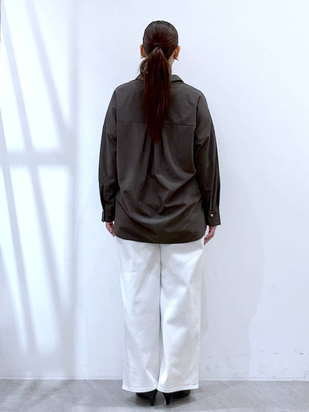 ホワイト系のデニムパンツ、ブラック系のハンドバッグ、ブラウン系のシャツ/ブラウスを着用したレディースの春コーディネートの4枚目の写真