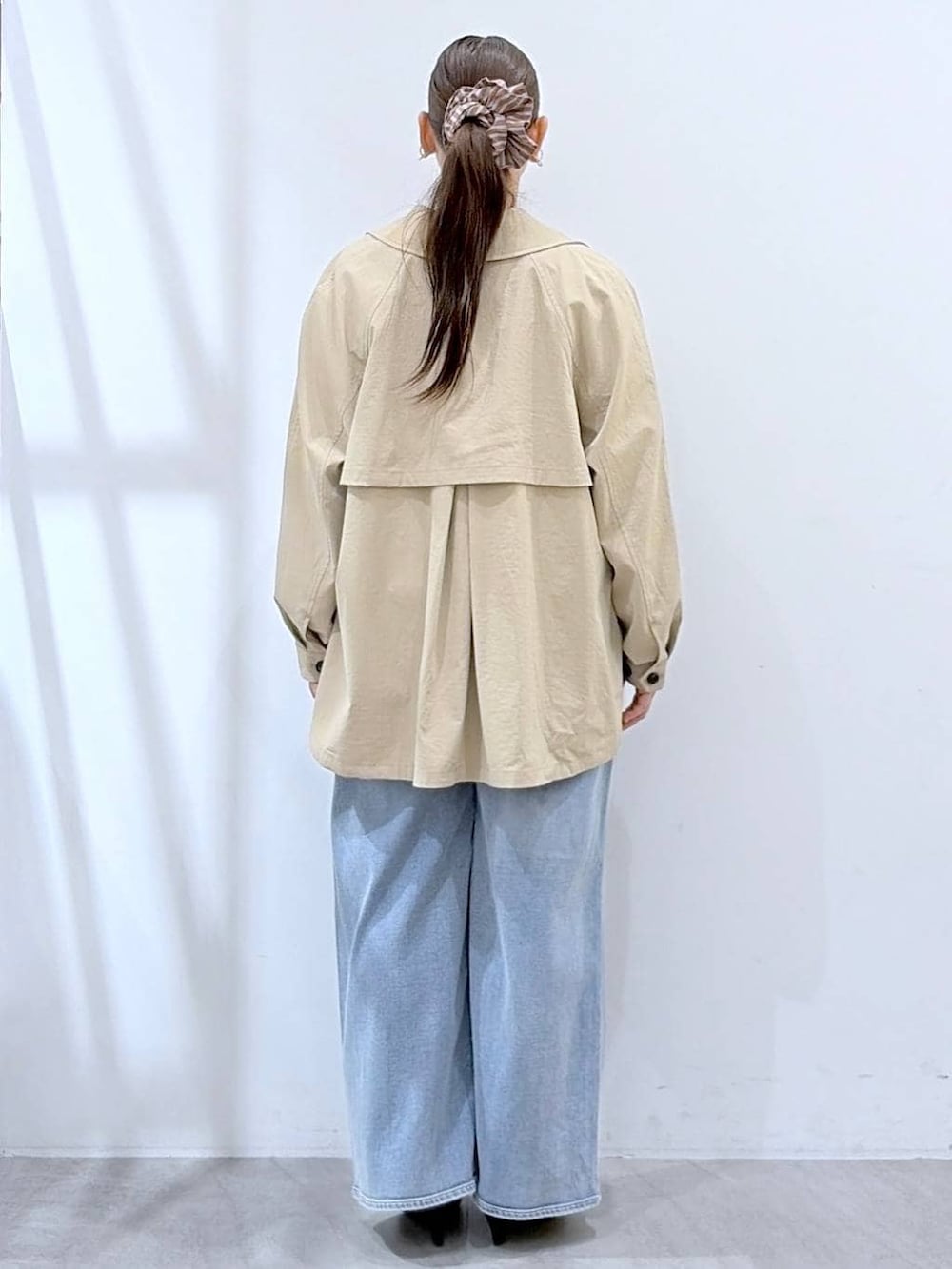 ホワイト系のニット/セーター、ブルー系のデニムパンツ、ブラック系のハンドバッグを着用したレディースの春コーディネートの4枚目の写真