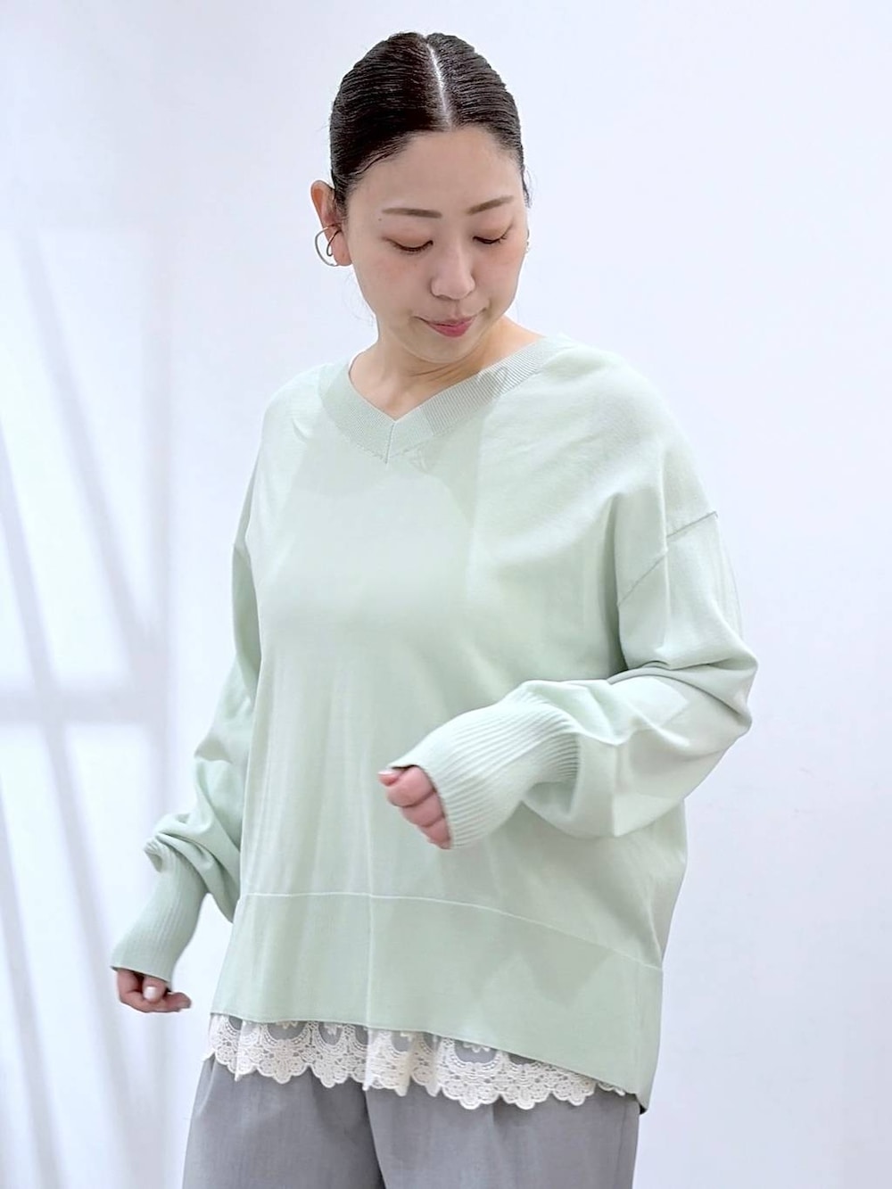 ホワイト系のタンクトップ、ブラック系のハンドバッグ、グレー系のその他パンツを着用したレディースの春コーディネートの7枚目の写真