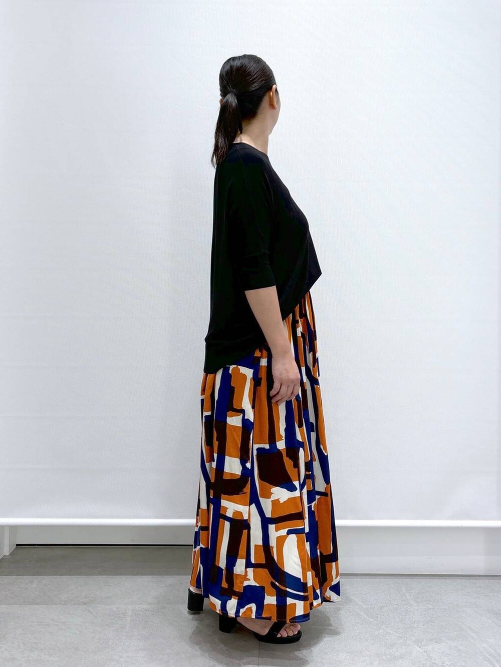 ブラック系のショルダーバッグ、ブラック系のサンダル、ブラック系のニット/セーターを着用したレディースの夏コーディネートの6枚目の写真