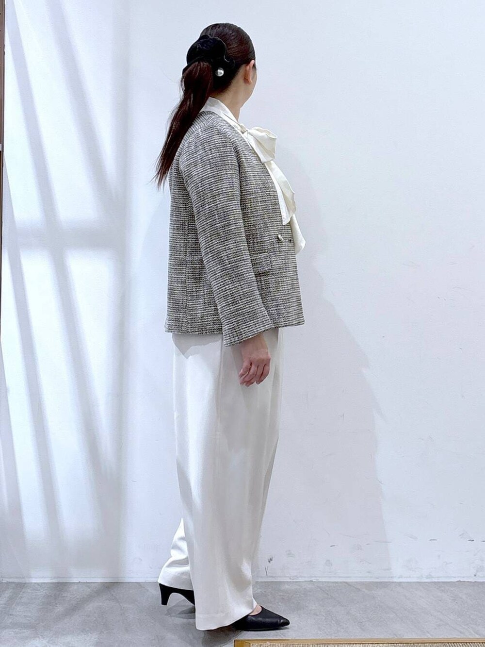 ブラック系のハンドバッグ、ブラック系のノーカラージャケット、ホワイト系のシャツ/ブラウスを着用したレディースの冬コーディネートの5枚目の写真