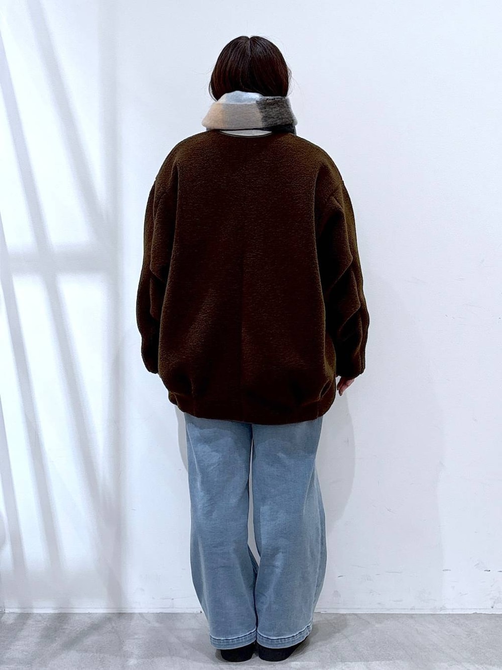 ブラック系のブーツ、ブラック系のボストンバッグ、ブラウン系のブルゾンを着用したレディースの冬コーディネートの4枚目の写真