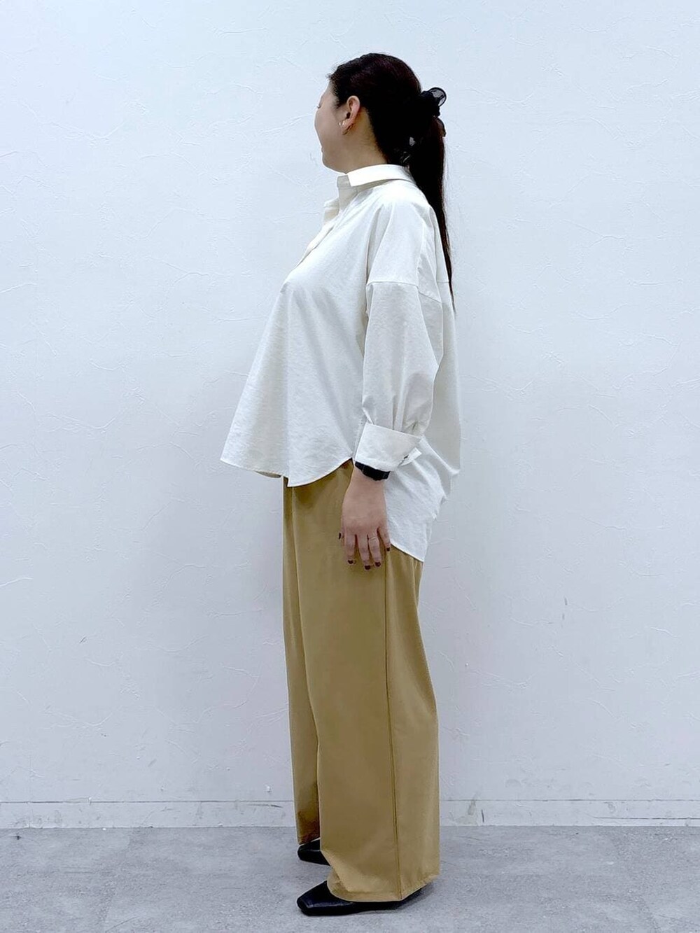 ブラック系のハンドバッグ、ブラック系のパンプス、ホワイト系のシャツ/ブラウスを着用したレディースの冬コーディネートの3枚目の写真