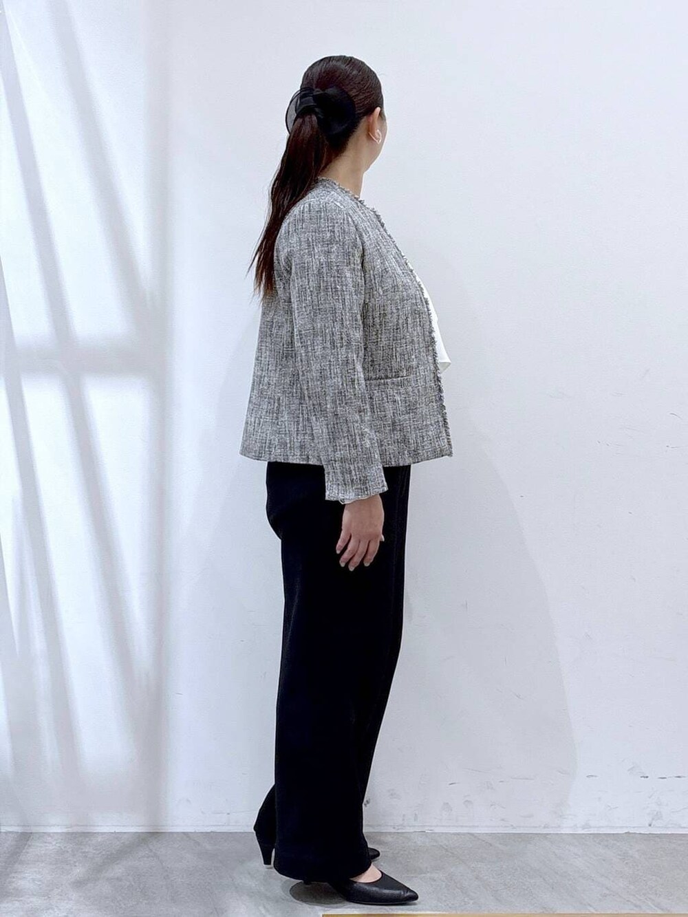 ブラック系のハンドバッグ、ブラック系のその他パンツ、ブラック系のノーカラージャケットを着用したレディースの冬コーディネートの5枚目の写真