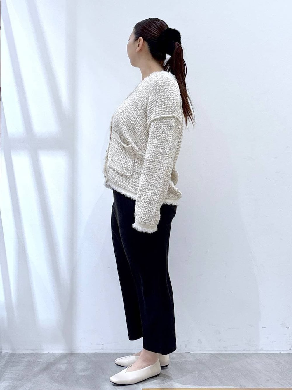 ベージュ系のスカート、ホワイト系のパンプス、ホワイト系のトートバッグを着用したレディースの冬コーディネートの3枚目の写真