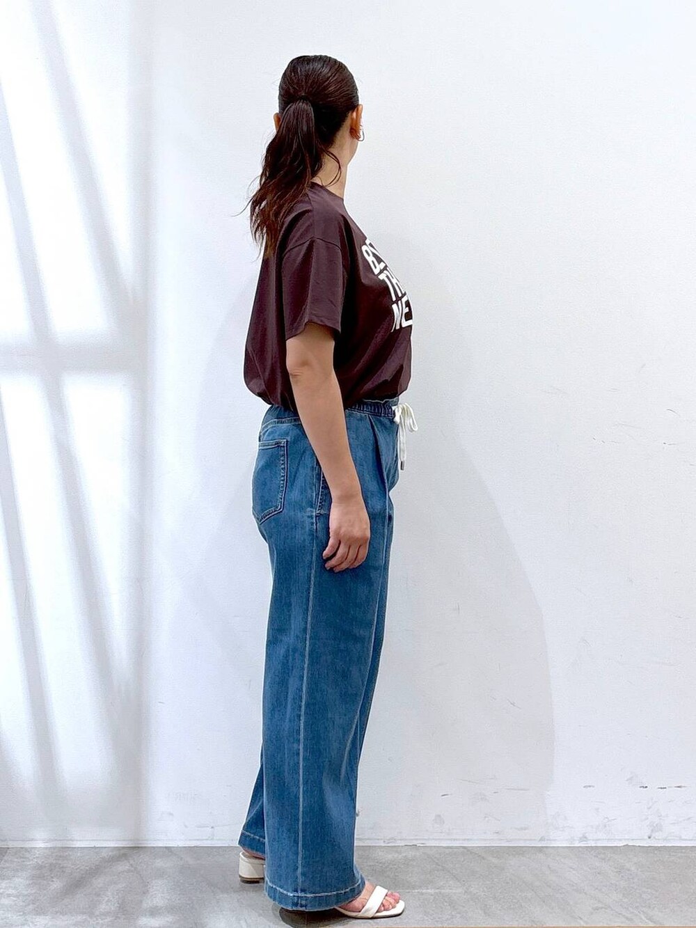 ホワイト系のトートバッグ、ブルー系のデニムパンツ、ブラウン系のTシャツ/カットソーを着用したレディースの夏コーディネートの5枚目の写真
