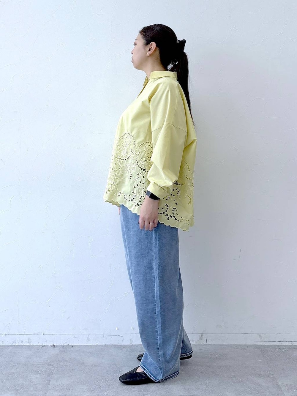 ブラック系のハンドバッグ、ブラック系のパンプス、ブルー系のデニムパンツを着用したレディースの冬コーディネートの3枚目の写真