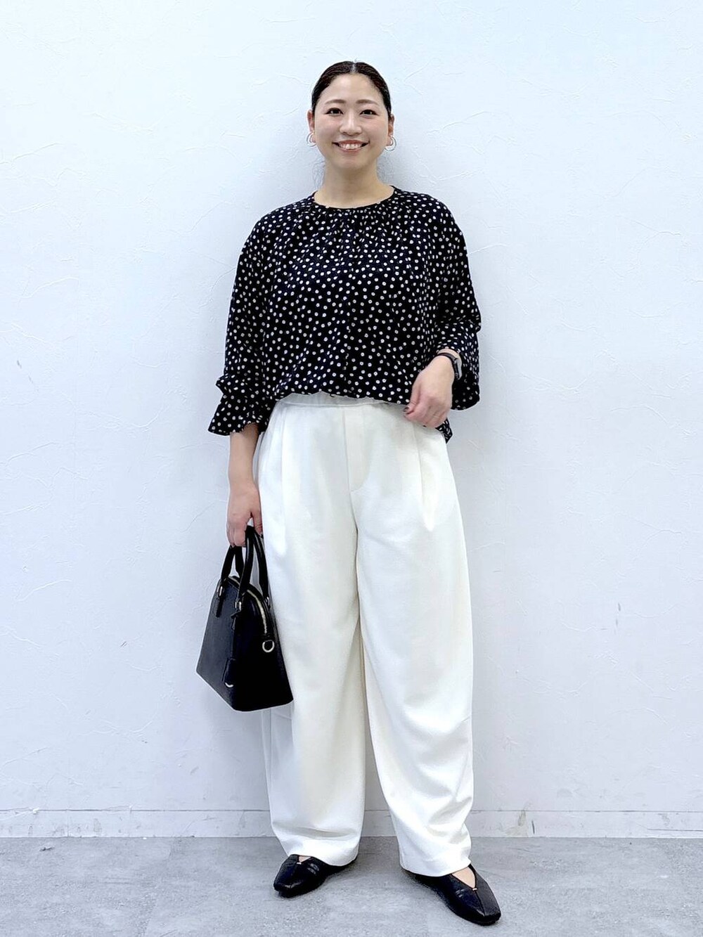 ブラック系のハンドバッグ、ブラック系のパンプス、ブラック系のシャツ/ブラウスを着用したレディースの冬コーディネートの2枚目の写真