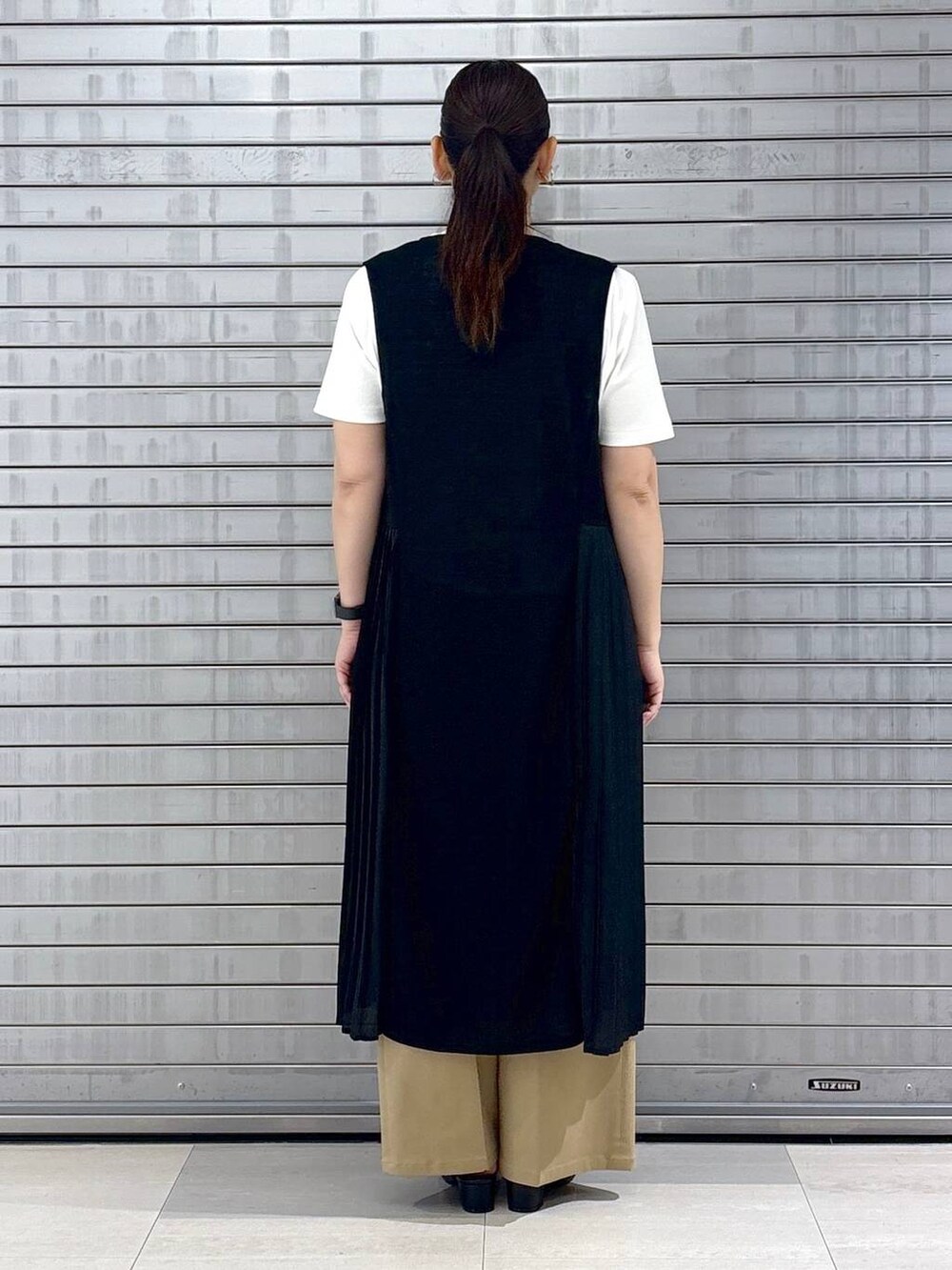 ブラック系のハンドバッグ、ホワイト系のTシャツ/カットソー、ブラウン系のその他パンツを着用したレディースの春コーディネートの4枚目の写真