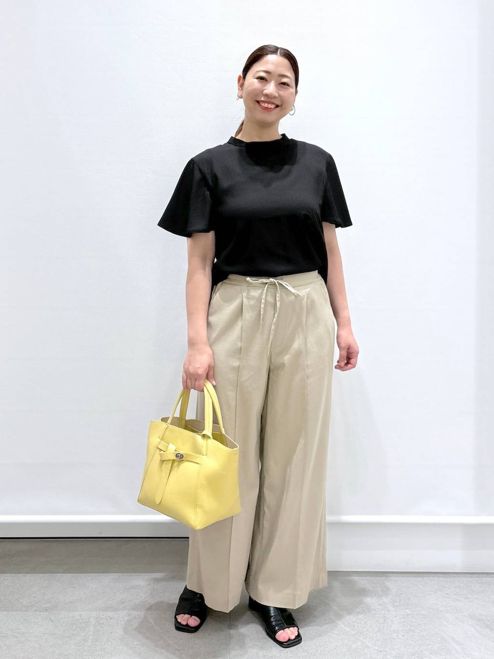 ベージュ系のその他パンツ、ブラック系のサンダル、ブラック系のシャツ/ブラウスを着用したレディースの春コーディネートの2枚目の写真